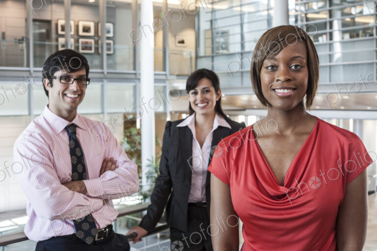 Mixed race team of business people in the lobby of a large office building.