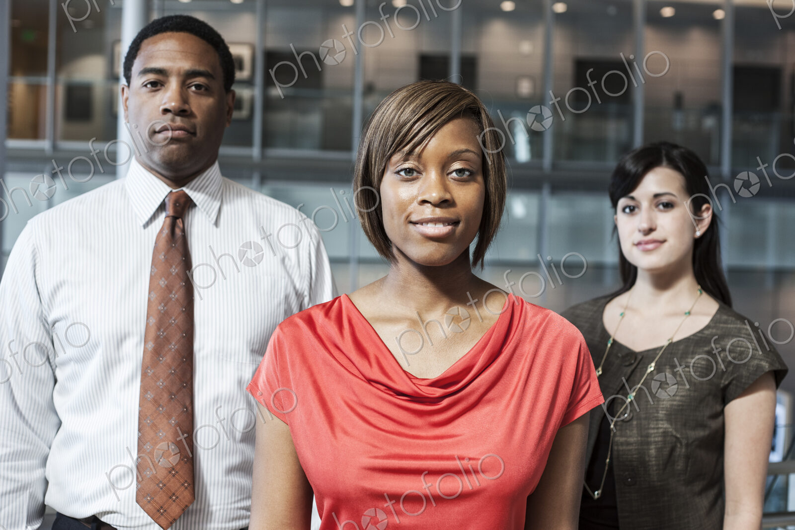 Mixed race team of business people in the lobby of a large office building.
