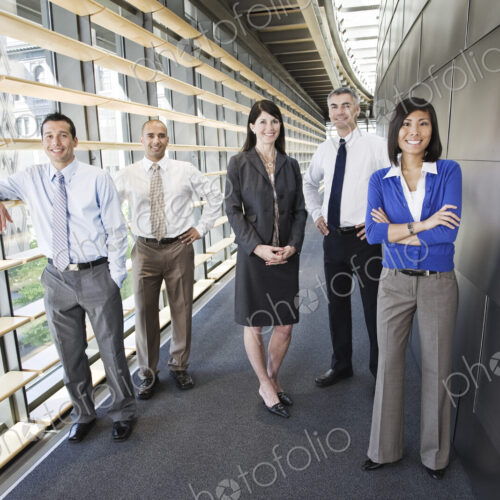 Mixed race team of business people in the lobby of a large office building.