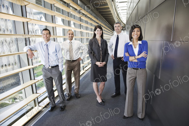 Mixed race team of business people in the lobby of a large office building.