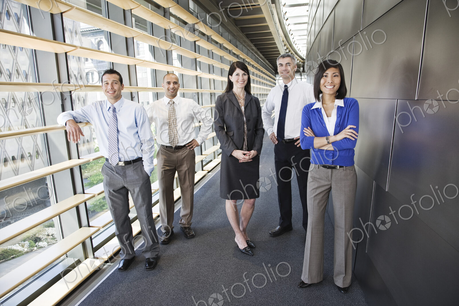 Mixed race team of business people in the lobby of a large office building.