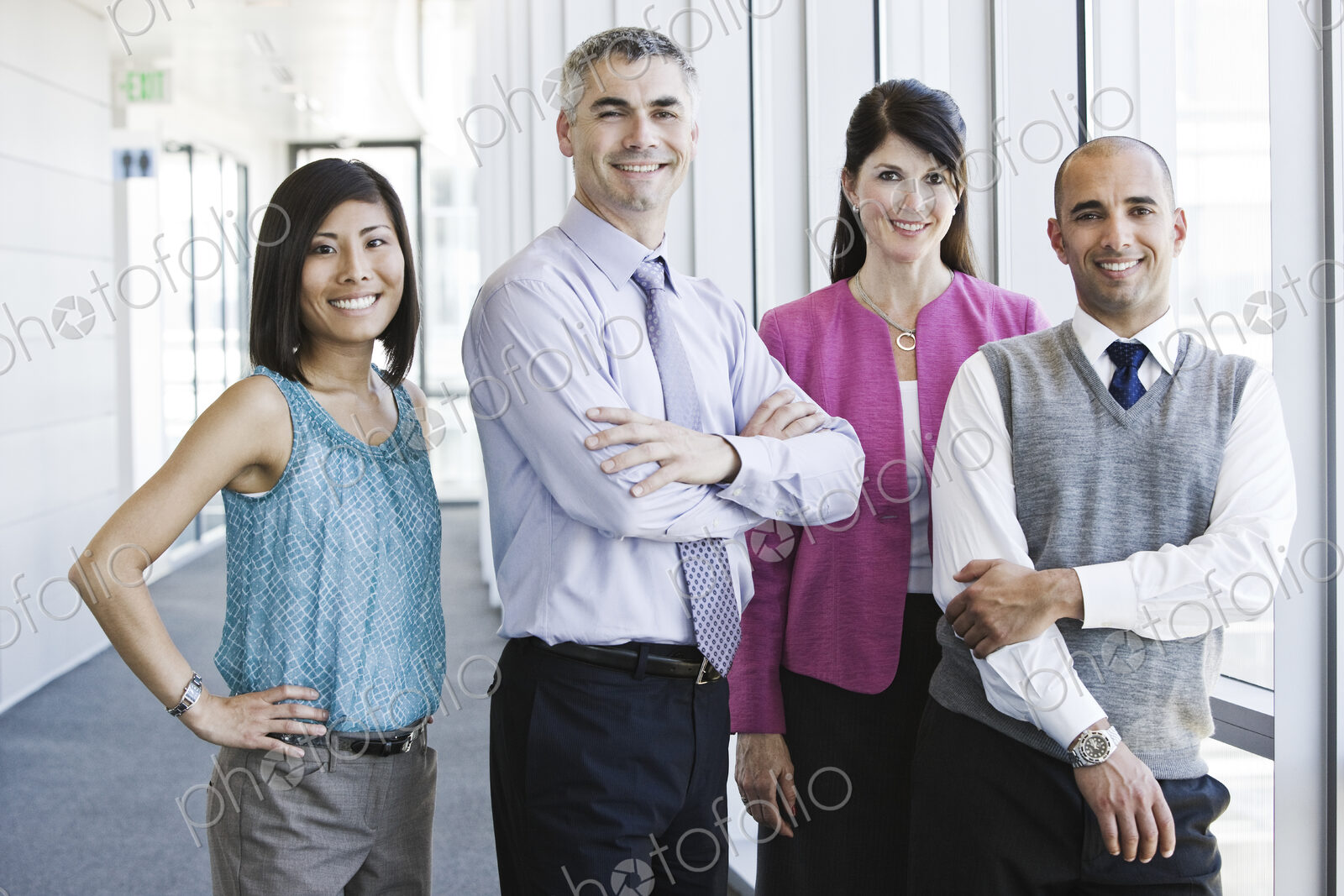 Mixed race team of business people in the lobby of a large office building.
