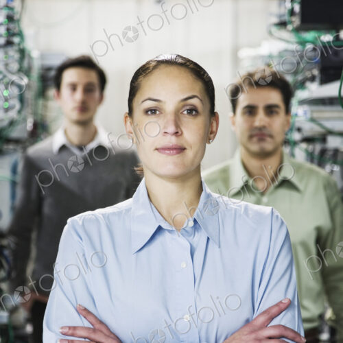 Mixed race team of technicians working on computer servers in a computer server farm. Mixed race team of technicians working on computer servers in a computer server farm.