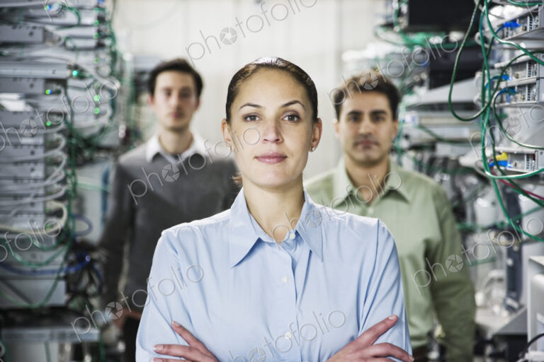 Mixed race team of technicians working on computer servers in a computer server farm.