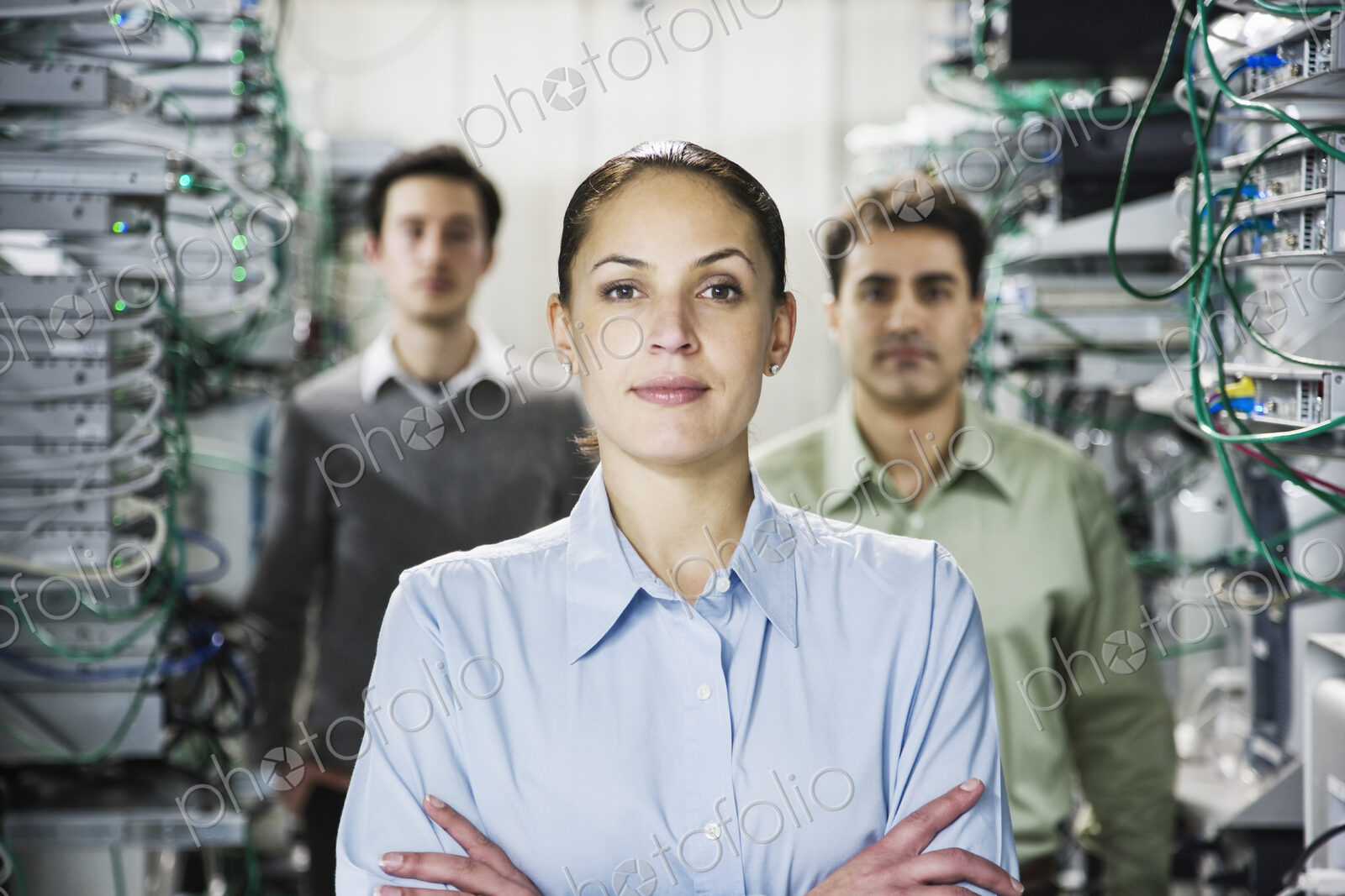Mixed race team of technicians working on computer servers in a computer server farm.