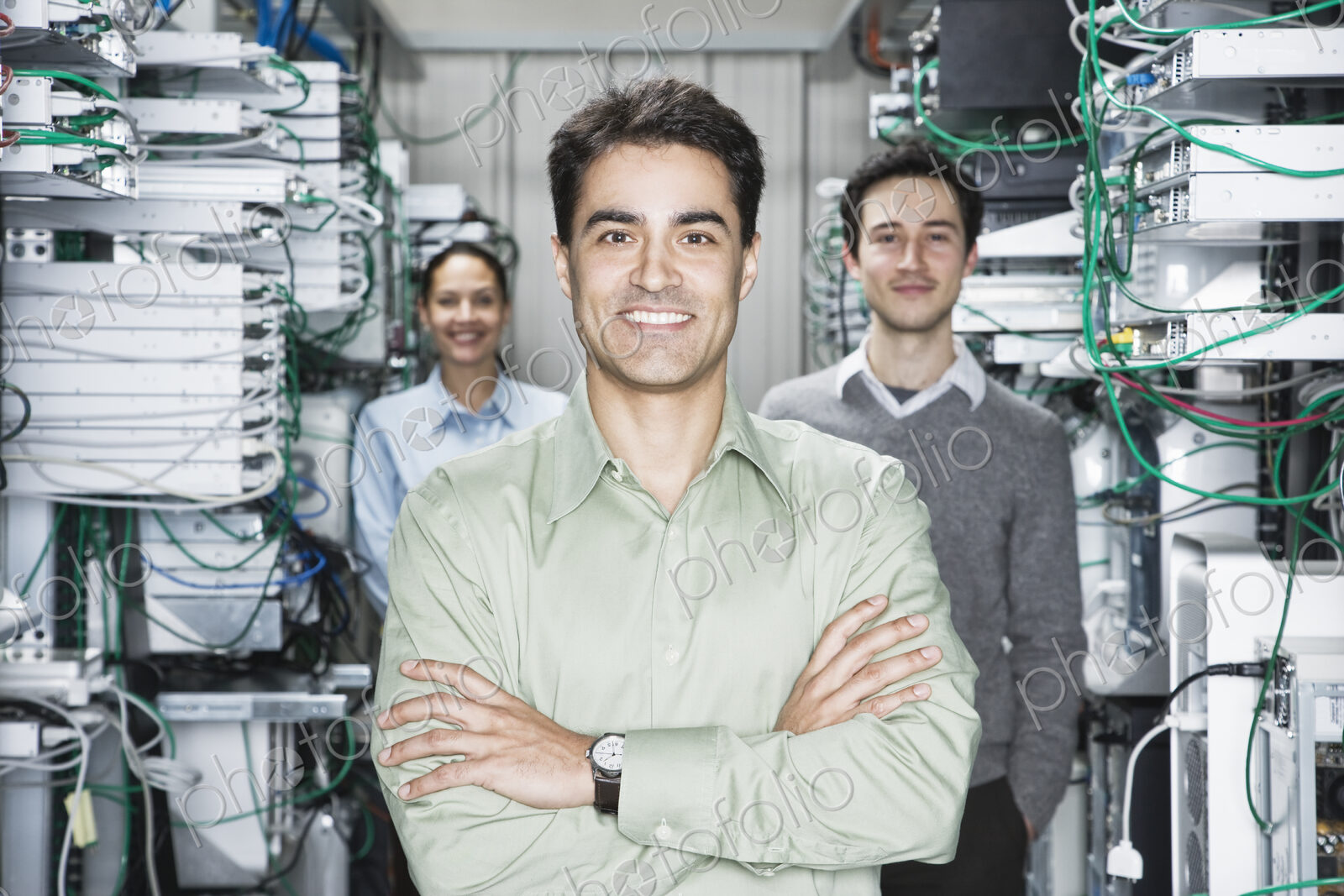 Mixed race team of technicians working on computer servers in a computer server farm.