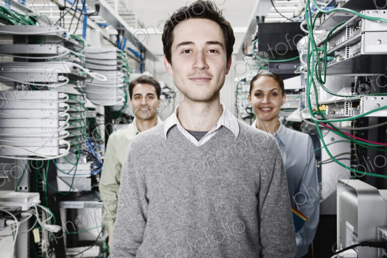 Mixed race team of technicians working on computer servers in a computer server farm.