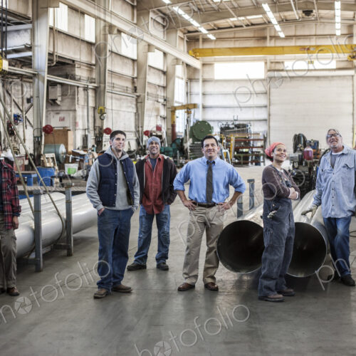 Mixed race team of workers and Hispanic manager in a sheet metal factory.