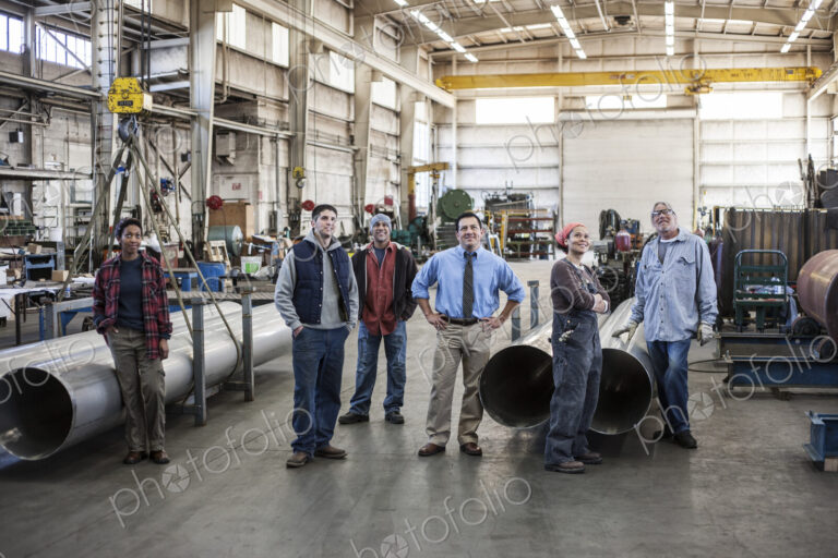 Mixed race team of workers and Hispanic manager in a sheet metal factory.