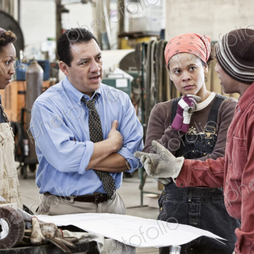 Mixed race team of workers and hispanic man manager talking over an issue in a sheet… Mixed race team of workers and hispanic man manager talking over an issue in a sheet…