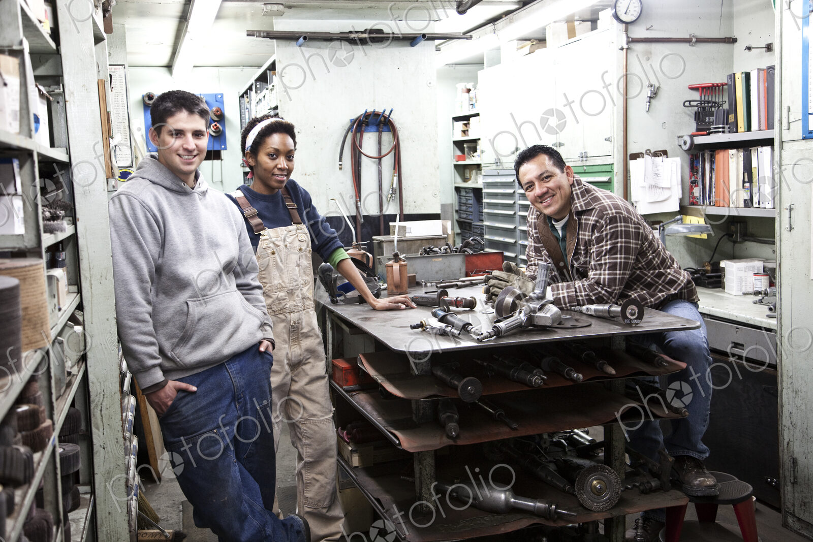 Mixed race team of workers and management people in a large sheet metal factory