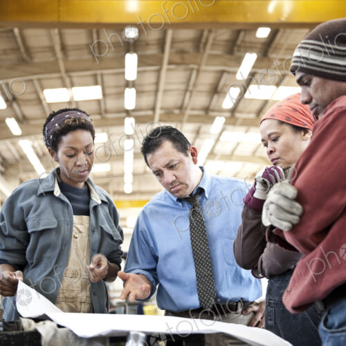 Mixed race team of workers and management people in a large sheet metal factory Mixed race team of workers and management people in a large sheet metal factory