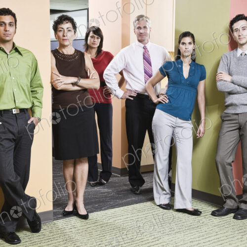 Mixed race team of workers in an office hallway.