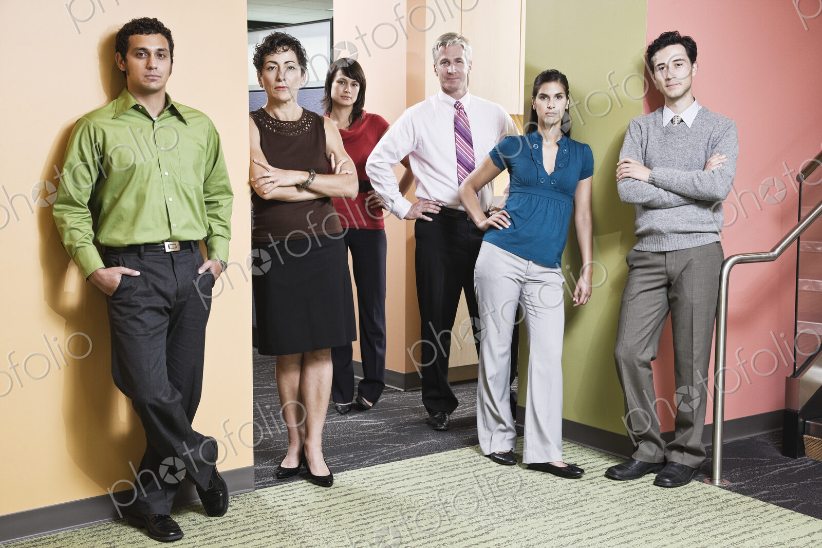 Mixed race team of workers in an office hallway.