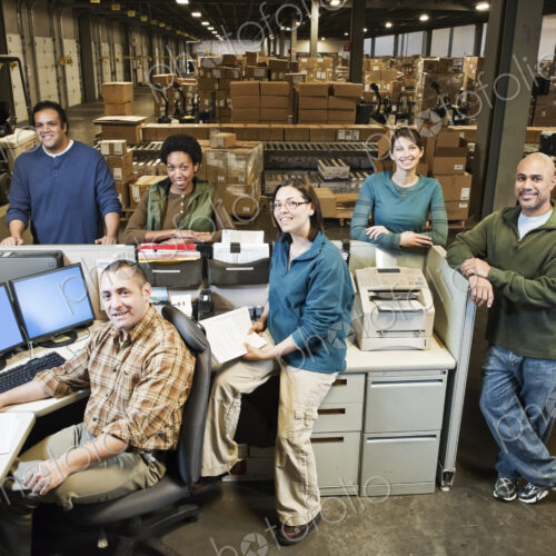 Mixed race warehouse workers at the front desk of a distribution warehouse. Mixed race warehouse workers at the front desk of a distribution warehouse.