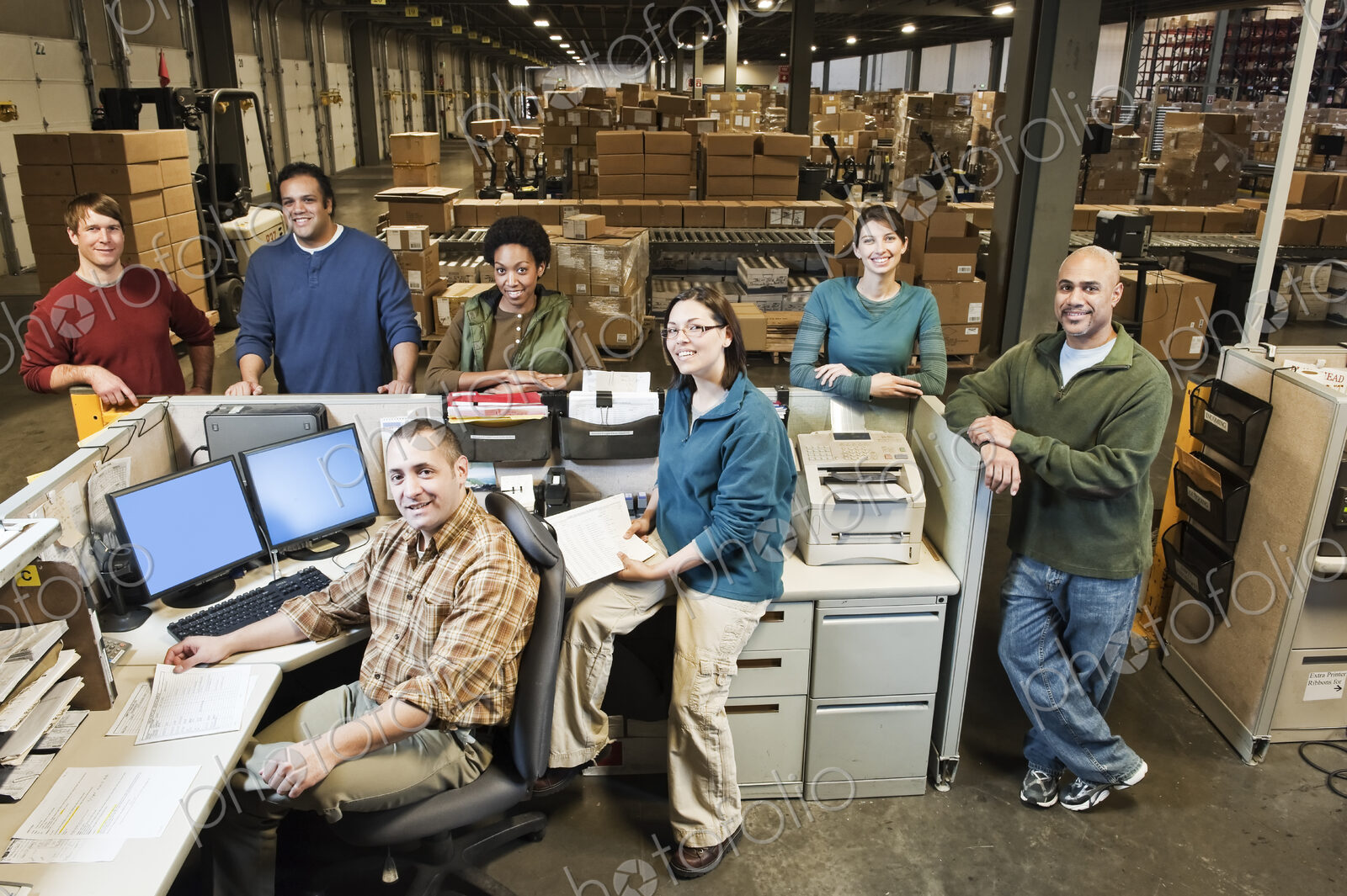 Mixed race warehouse workers at the front desk of a distribution warehouse.