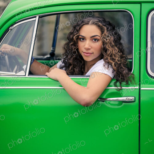 Mixed race woman driving green car