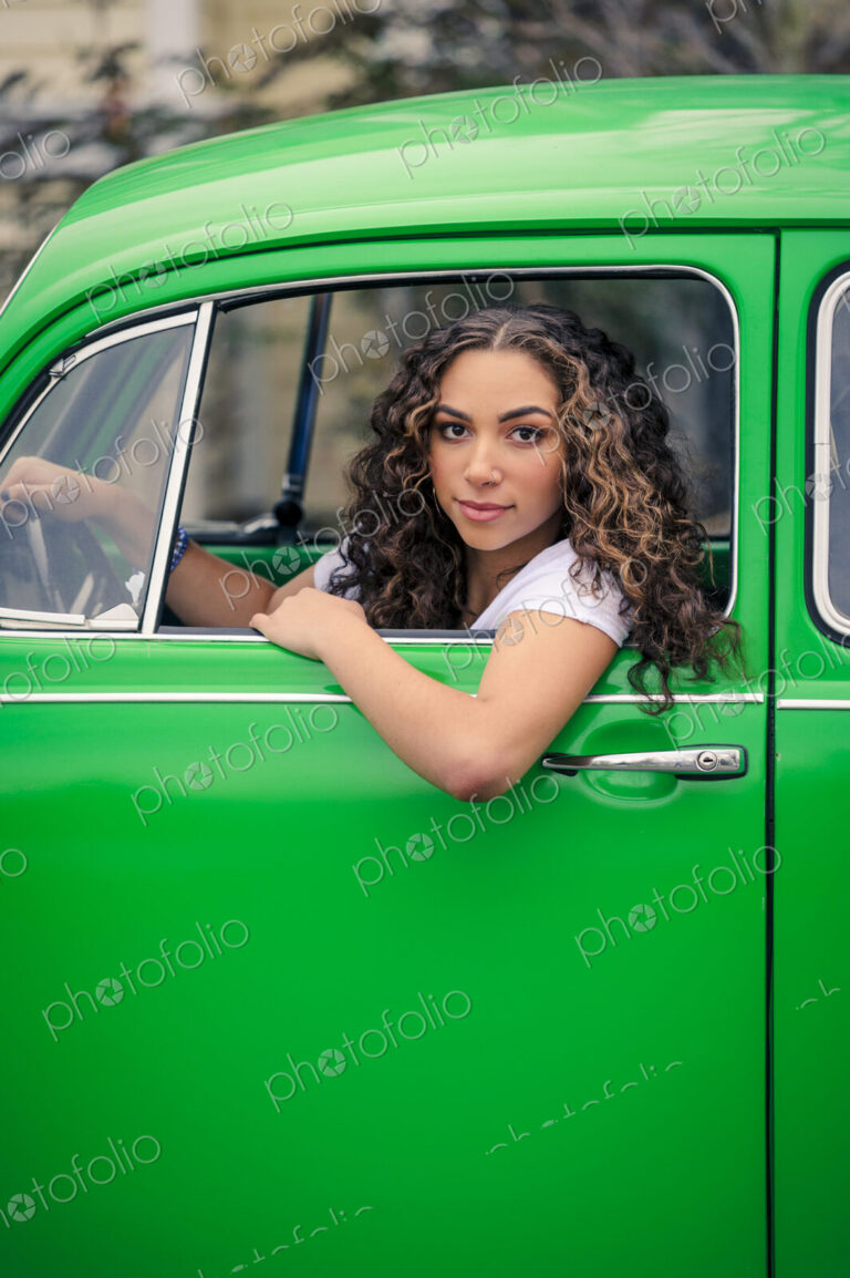 Mixed race woman driving green car