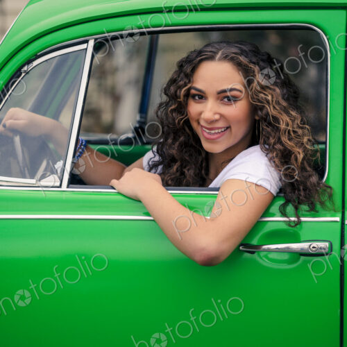 Mixed race woman driving green car
