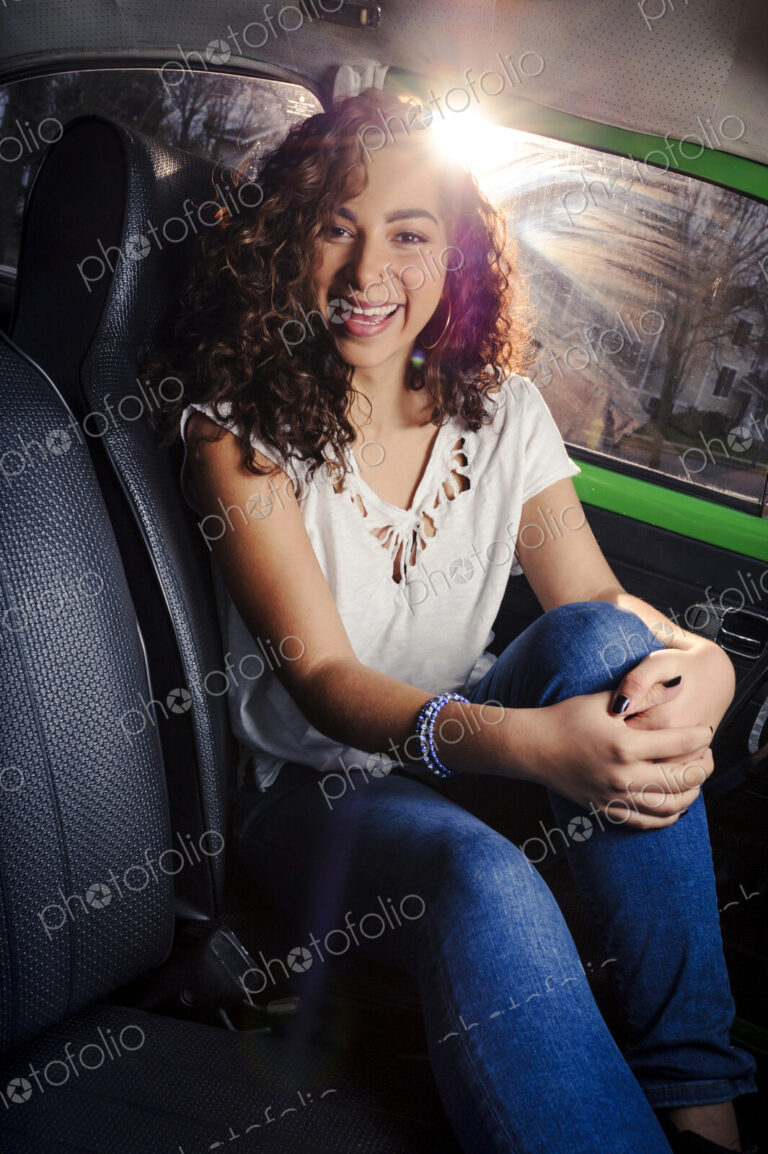 Mixed race woman smiling in car