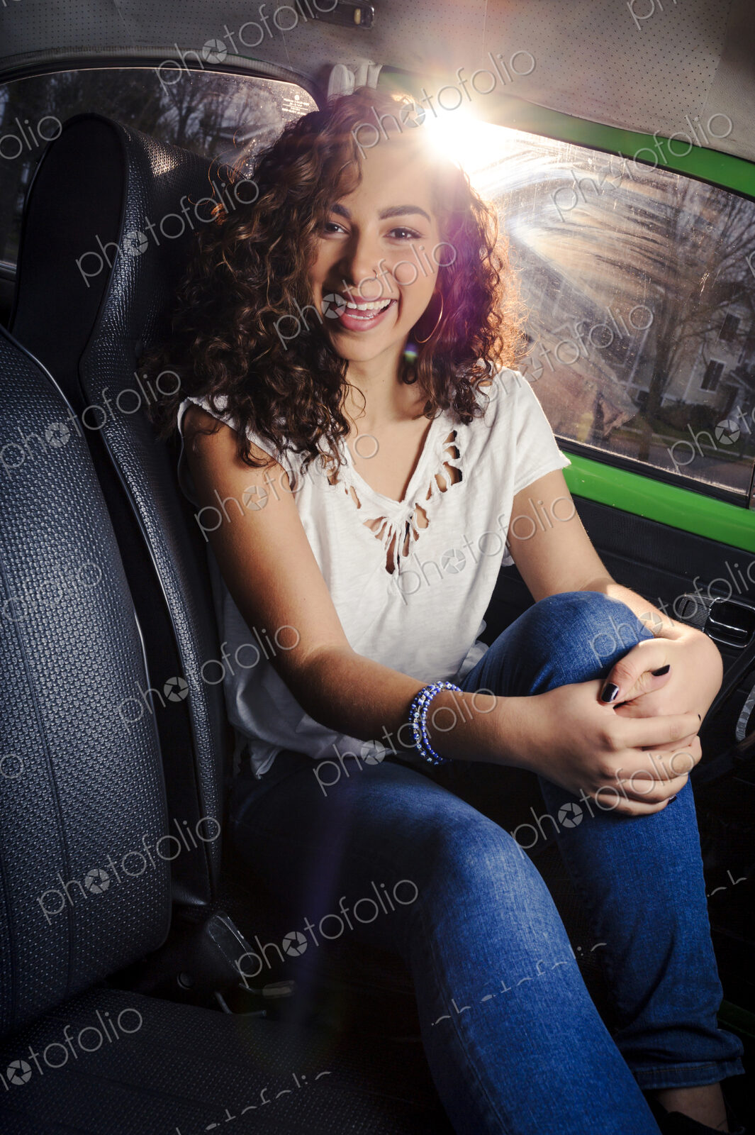 Mixed race woman smiling in car