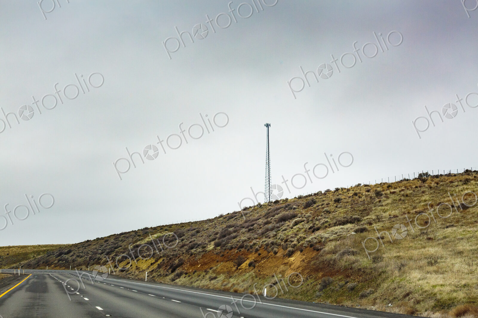 Mobile phone tower in rural desert landscape above Interstate 90