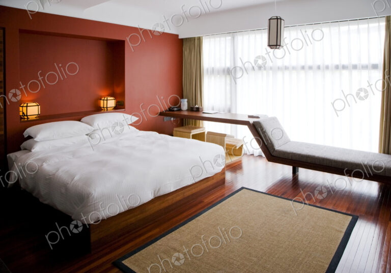 Modern bedroom, with double bed and wall recess and chaise longue by window