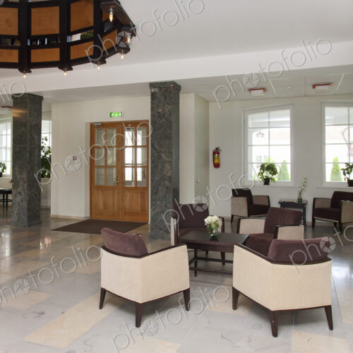 Modern building interior, hotel, reception area, pillars and tiled floor, fireplace…