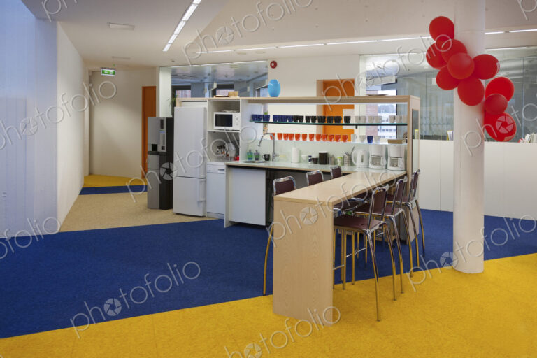Modern college building, red balloons on a pillar, blue and yellow flooring, and…
