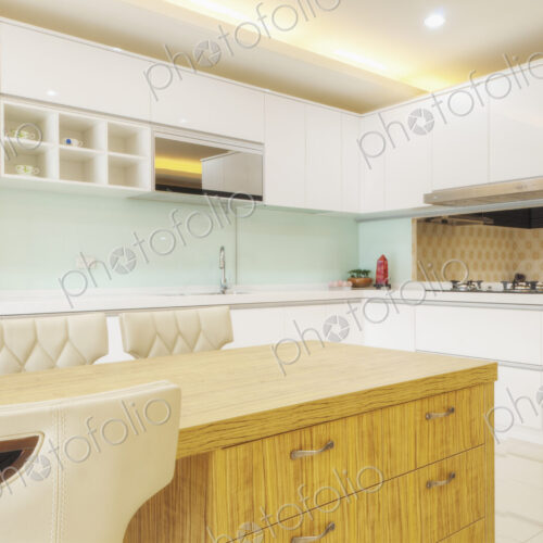 Modern kitchen interior with two sinks, gas stove, fitted cupboards and appliances.