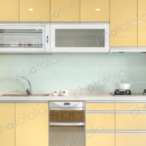 Modern kitchen with red cabinets, two sinks, gas stove, fitted cupboards, electrical…