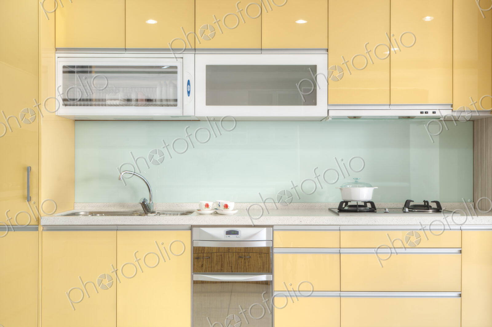 Modern kitchen with red cabinets, two sinks, gas stove, fitted cupboards, electrical…