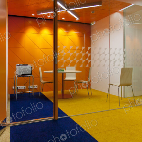 Modern meeting area in an office, a clear glass wall and chairs and table.