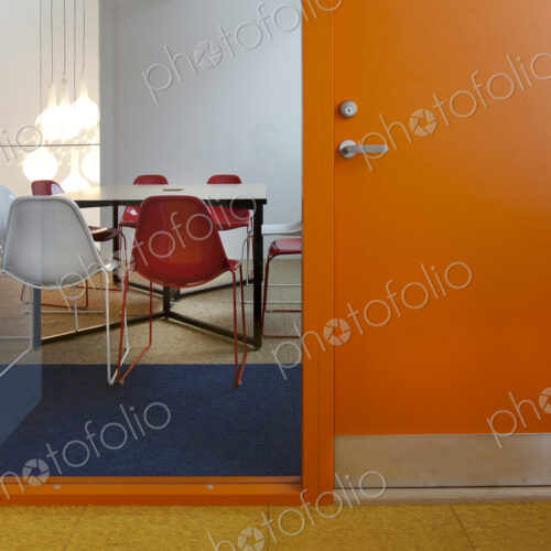 Modern meeting area in an office or college, a glass panel annd view into a small room.