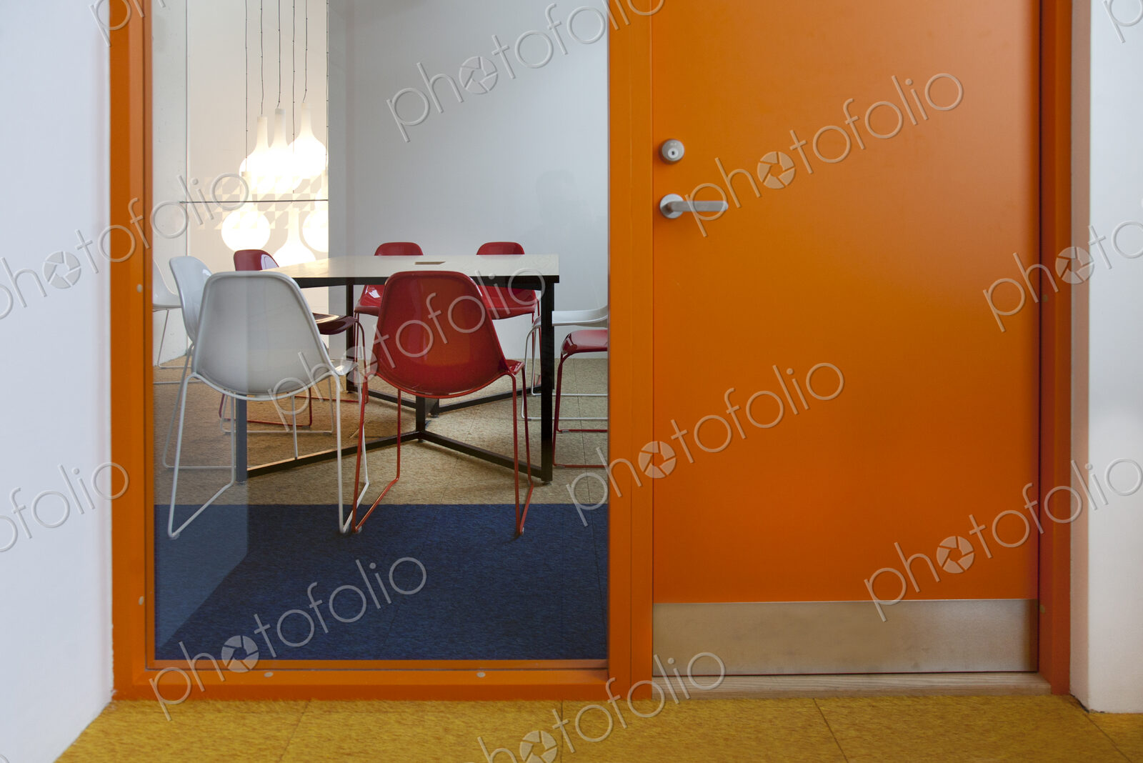 Modern meeting area in an office or college, a glass panel annd view into a small room.