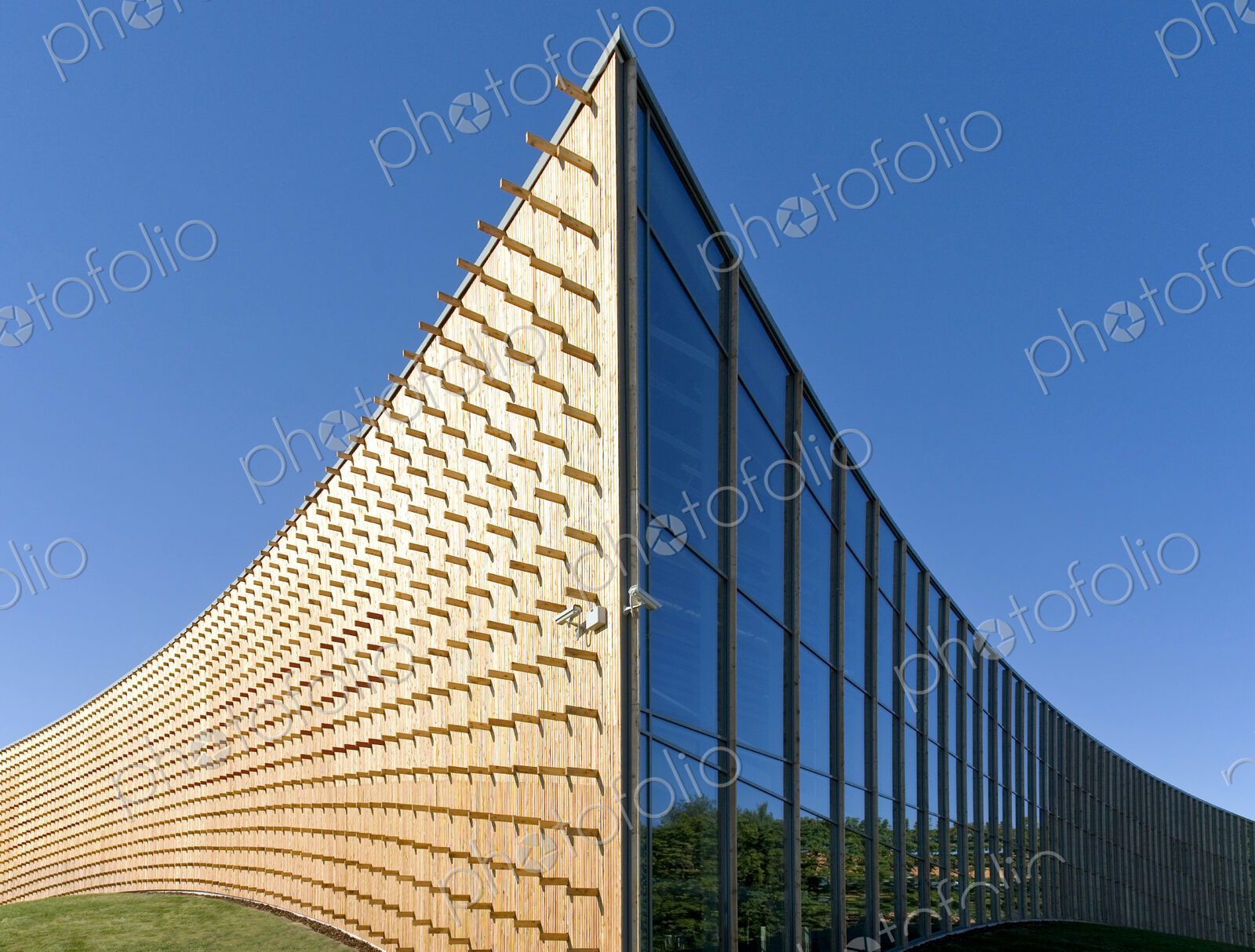 Modern university buildings, curved wooden walls and glass.
