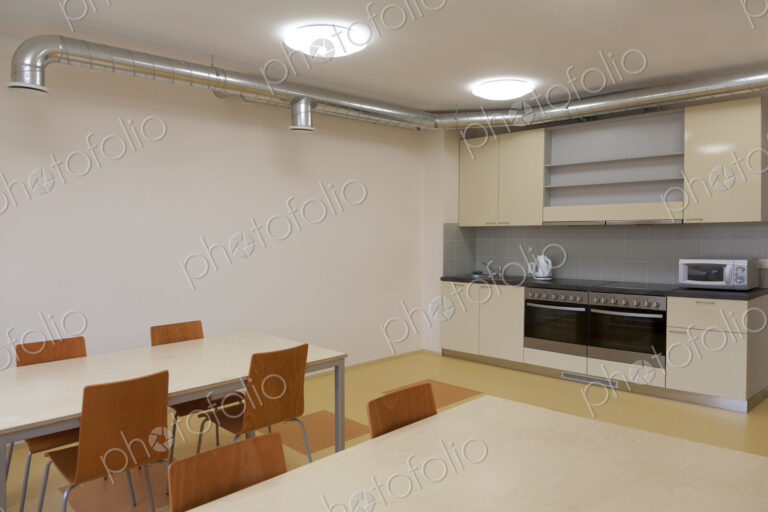 Modern youth hostel building. Kitchen and eating areas. Two ovens,kettle and toaster.