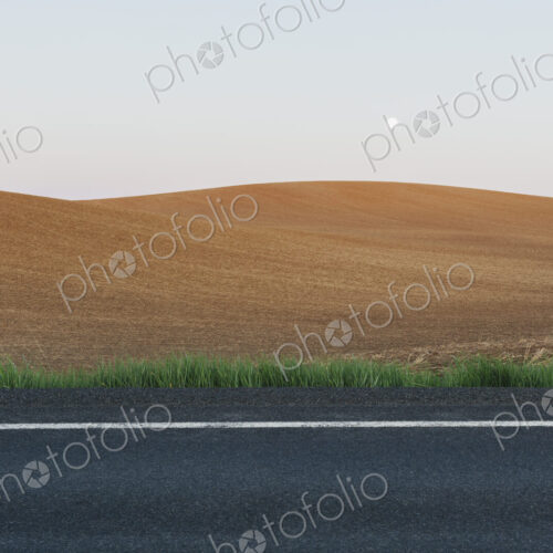 Moonrise over rolling freshly planted fields, road in foreground Moonrise over rolling freshly planted fields, road in foreground