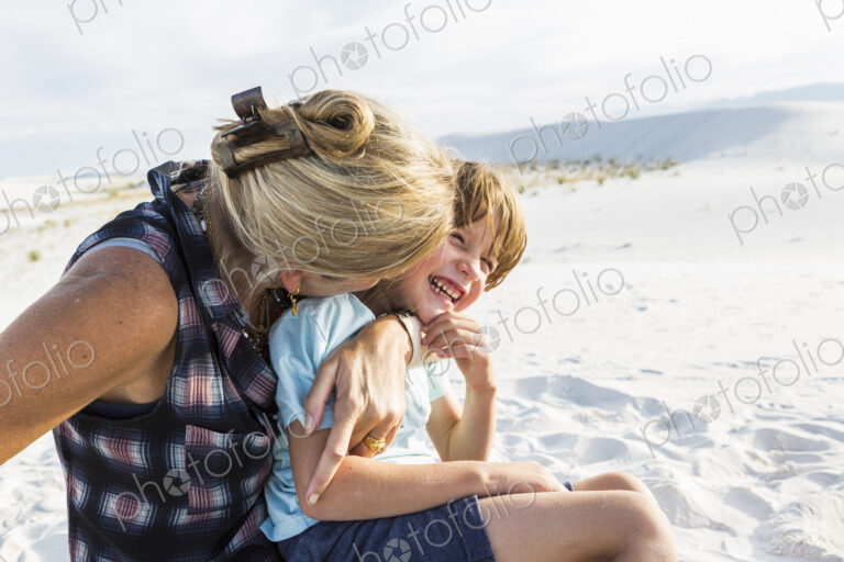 Mother and her 6 year old son embracing, White Sands Nat'l Monument, NM