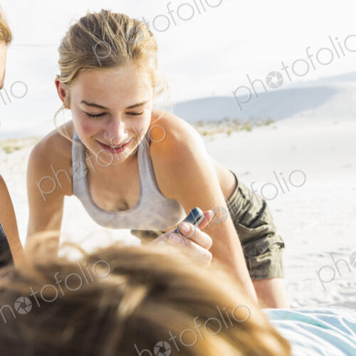 Mother looking at her smart phone as her kids look on Mother looking at her smart phone as her kids look on