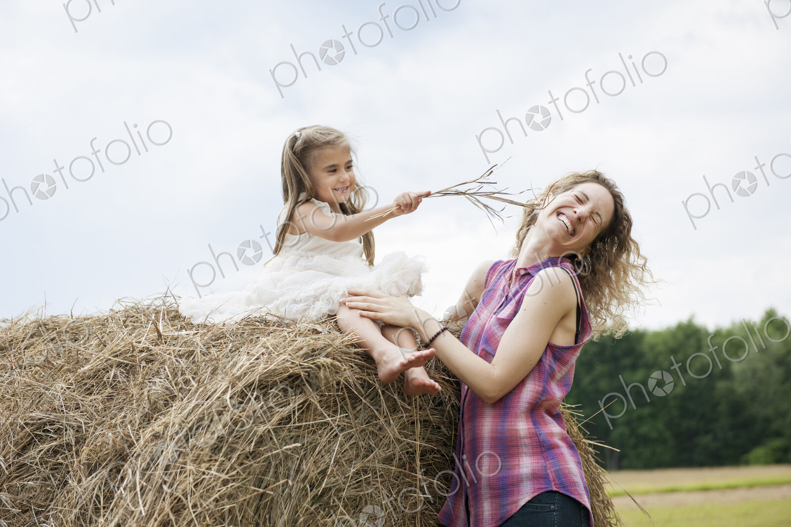 Mother playing outdoors with her daughter.