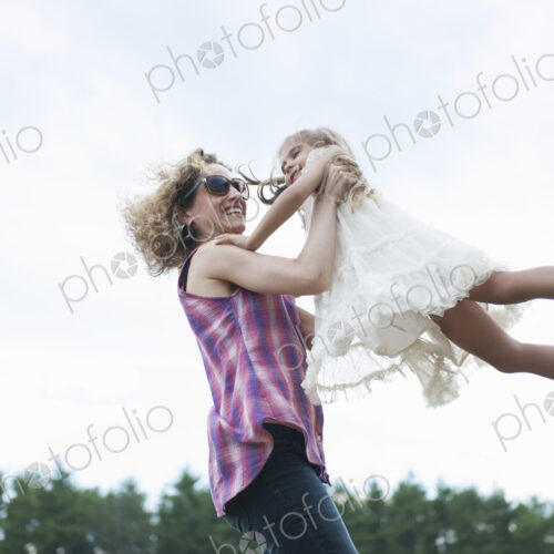 Mother playing outdoors with her daughter.