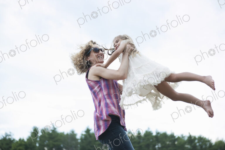 Mother playing outdoors with her daughter.