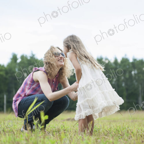 Mother playing outdoors with her daughter.