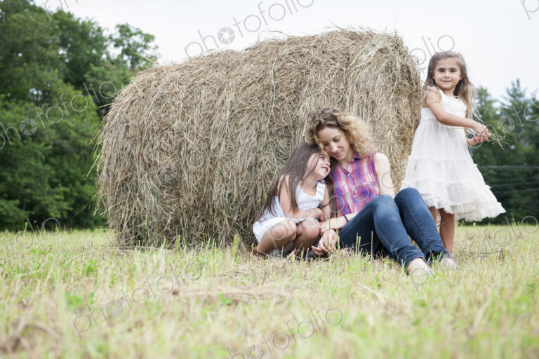 Mother playing outdoors with her daughters.