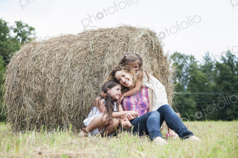Mother playing outdoors with her daughters.
