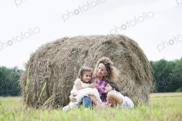 Mother playing outdoors with her daughters.