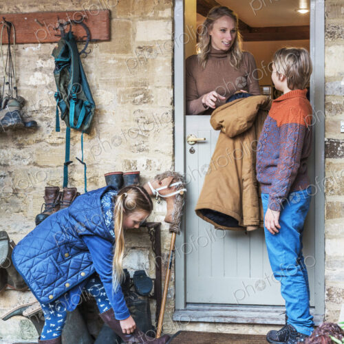 Mother standing in a doorway with son and daughter Mother standing in a doorway with son and daughter