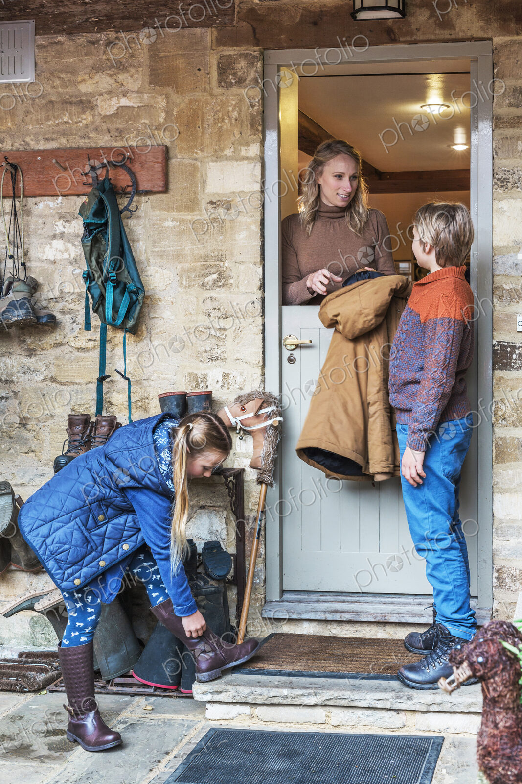 Mother standing in a doorway with son and daughter