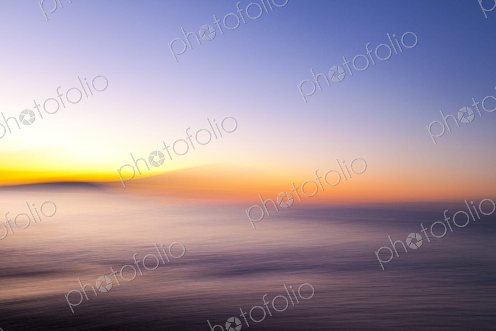 Motion blurred beach at sunset, a red glow on the horizon.